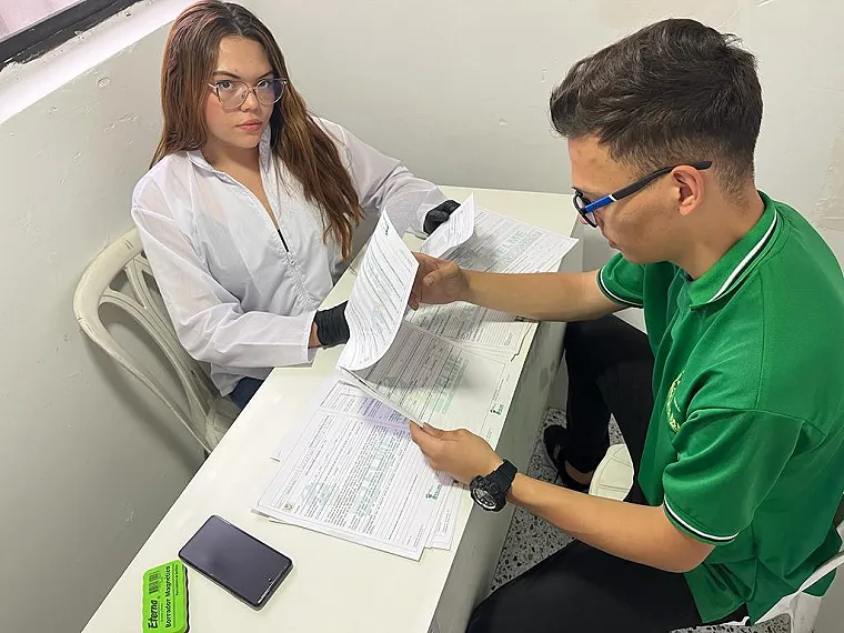 Una estudiante y un asesor revisan juntos unos formularios