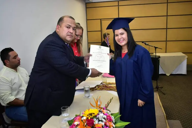 Graduada recibiendo su diploma de manos de un directivo
