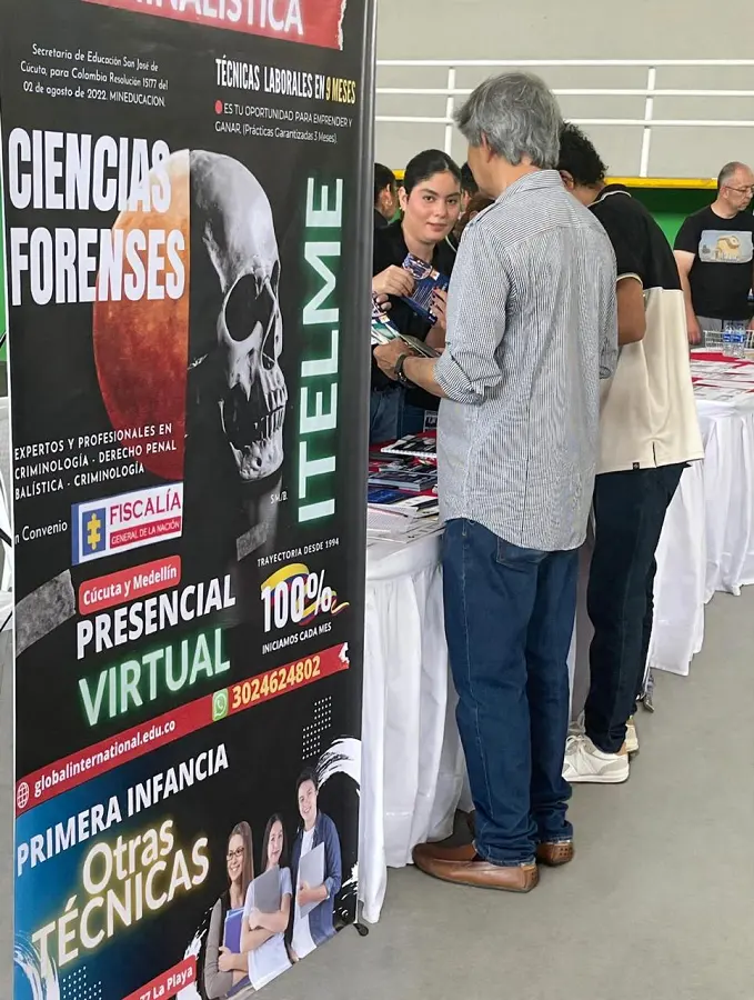 Stand de ITELME en una feria educativa con pendón de Ciencias Forenses