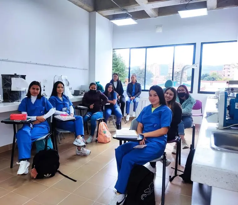 Estudiantes con uniforme azul en clase práctica dentro de un laboratorio