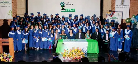 Graduados de ITELME con toga azul en el escenario durante su ceremonia de grado